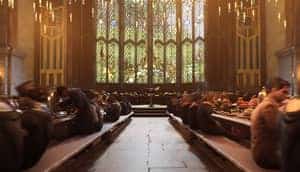 Scene from Hogwarts Legacy where students are sitting and eating